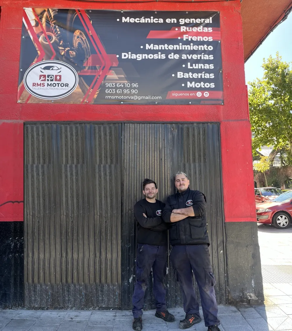 Rafael y Daniel delante de la fachada de RMS Motor, con la lona del taller